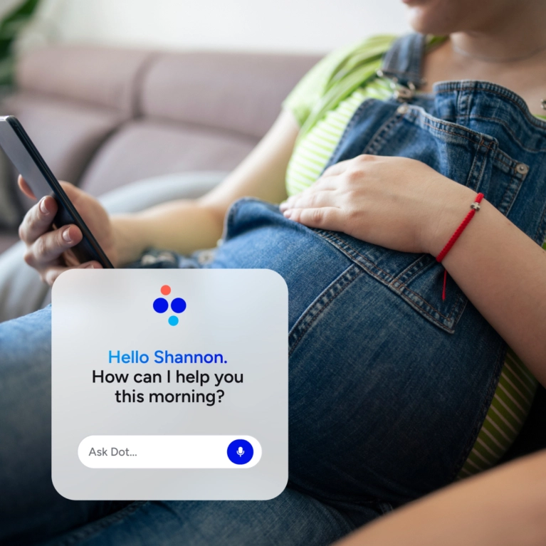 Close up of woman with pregnant belly in jeans looking at her phone. App interface overlays the image. It says: Helo Shannon. How can I help you this morning.
