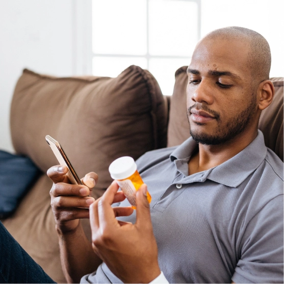man with smartphone and pill bottle