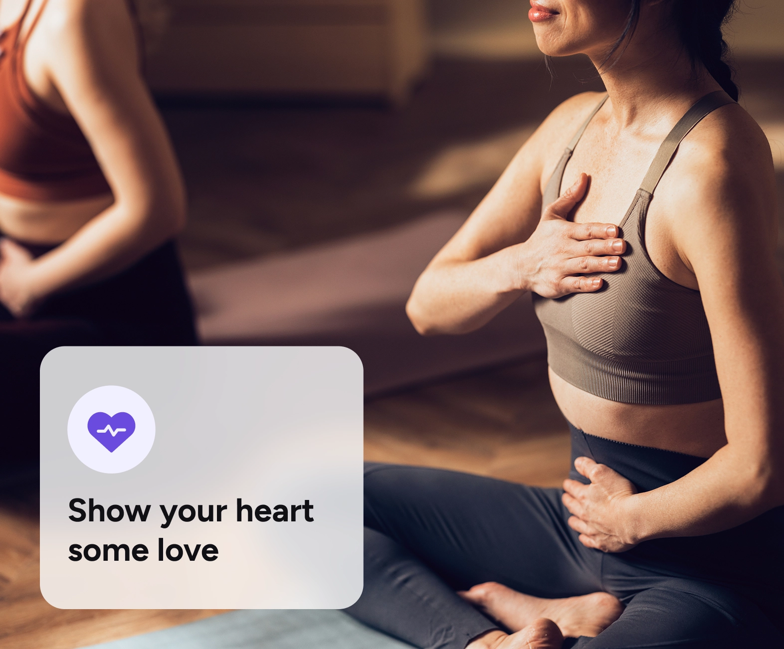 A woman in a yoga class putting her hand over her heart