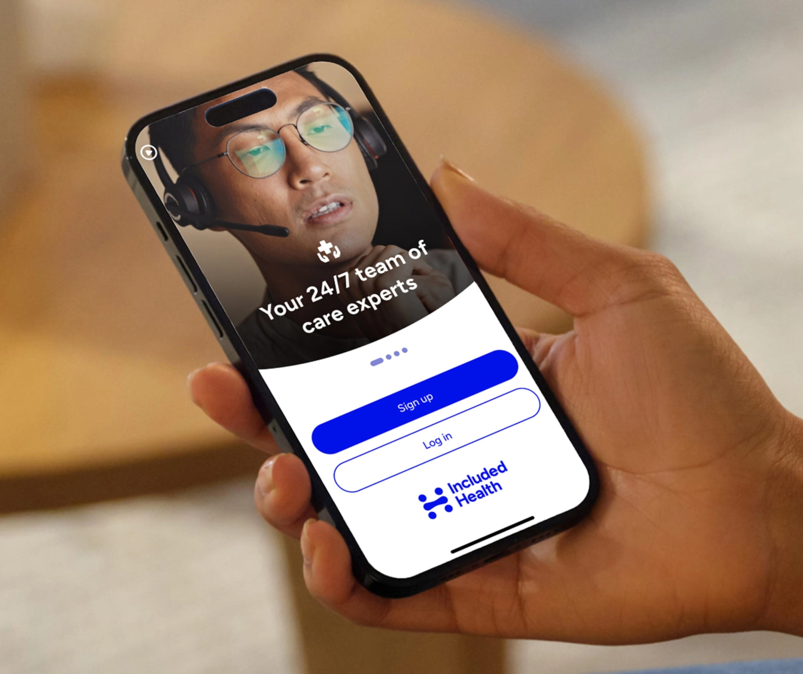 A hand holding a phone with the Included Health app on it.
